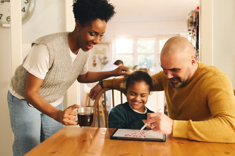 Parents and son with Down syndrome drawing on digital tablet